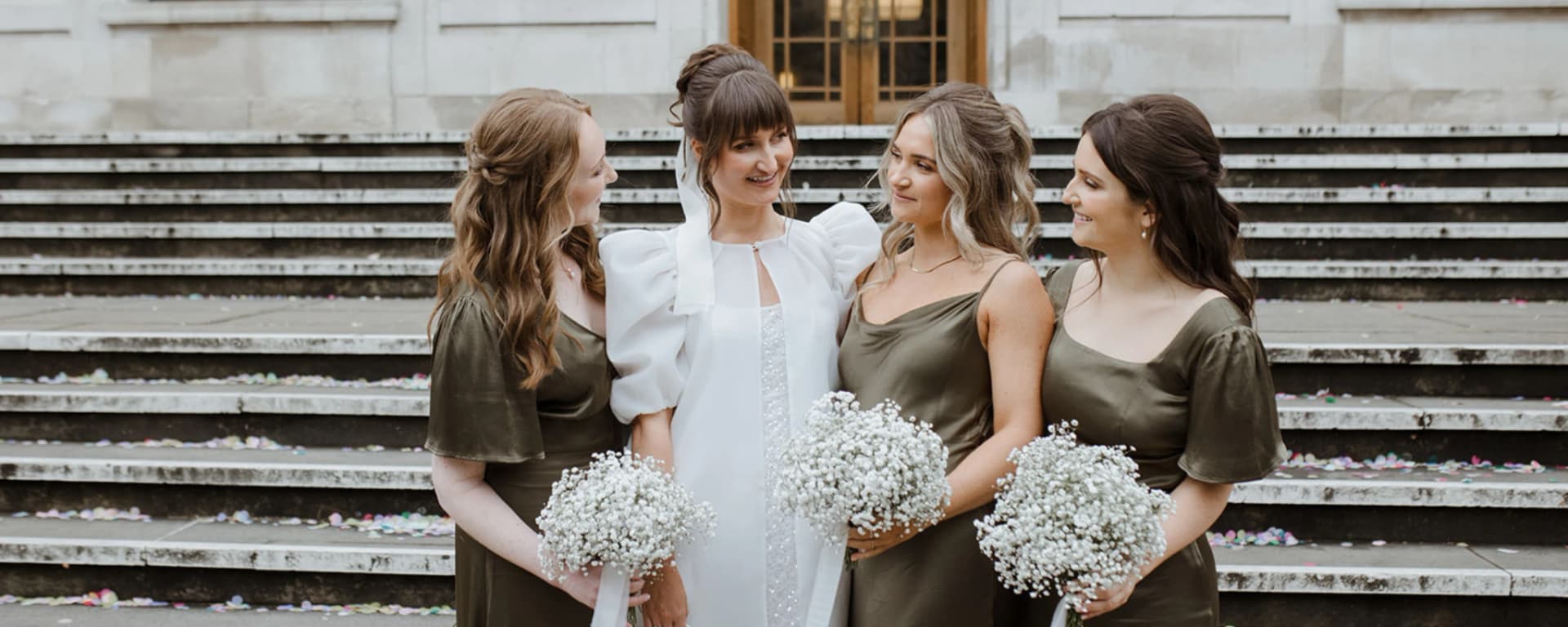 Luxury London bridal hair and makeup for bride and bridesmaids photographed outside a historic London wedding venue.